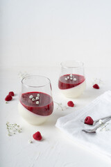 Italian dessert with raspberries. Creamy panna cotta with berry confit. White background with...