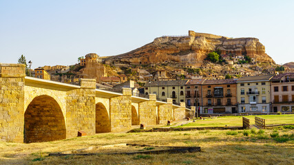 Roman bridge over the Douro River with the medieval village of San Esteban de Gorman in the...