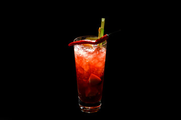 Red cocktail with chili pepper decoration on black background.