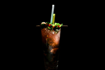 Alcoholic cocktail on a black background, decorated with a skewer with berries and straws.