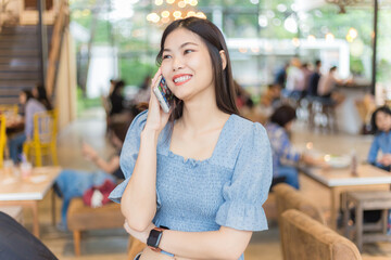 Business women talking on smartphone in cafe blurred group of people background
