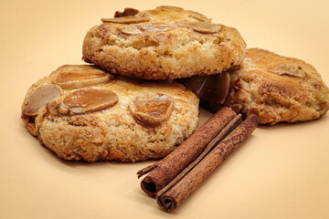 homemade sweet almond cookies biscuits (amaretti) isolated on orange with cinnamon sticks