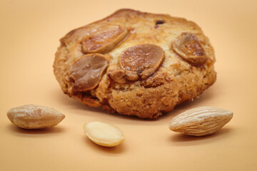 homemade sweet almond cookies biscuits (amaretti) isolated on orange with three almonds