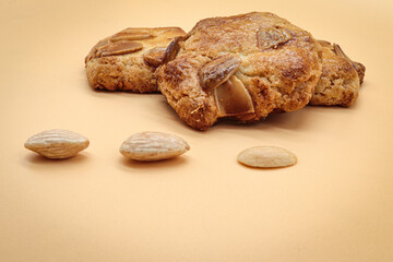 homemade sweet almond cookies biscuits (amaretti) isolated on orange with three almonds