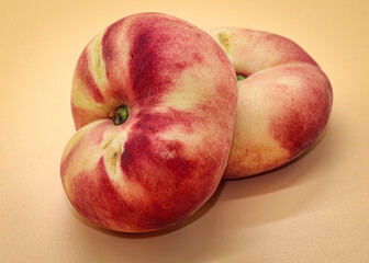two flat peaches isolated on orange background