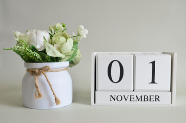 November 1, Cover natural background, white wooden Calendar cube with a pot flower on white...