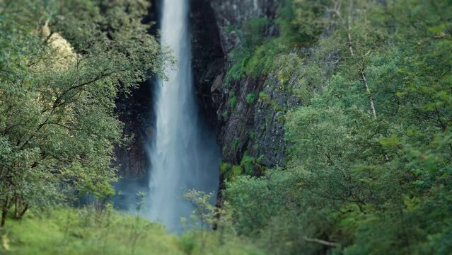 A view of the massive waterfall falling into a deep gorge. Pan right, slow-motion.