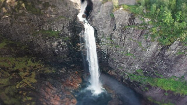 Aerial view of the massive waterfall falling into a deep gorge. water dust rising high in the air. Slow-motion.