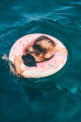 Baby girl swimming with Inflatable ring in the sea.