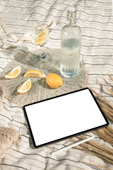 Mockup of new version tablet in trendy thin frame design with white screen lying on a picnic...