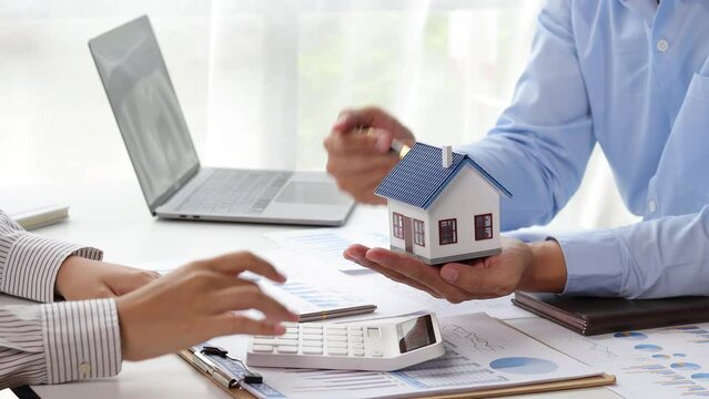 Real estate agents who are discussing and introducing examples of housing estates are offering housing project prices to clients.