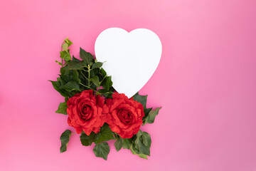 Fototapeta na wymiar Red roses with heart on pink background, space for text