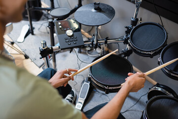 Cropped view of african american customer playing electronic drums in music shop.