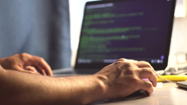 Male programmer. Human hands. Laptop on the table. Program code on the screen. Computational operations. Application programming. View code. Tester. IT-specialist. Close-up.