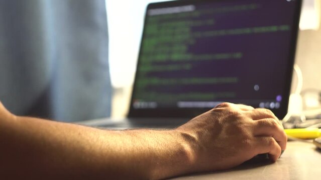 Male programmer. Human hands. Laptop on the table. Program code on the screen. Computational operations. Application programming. View code. Tester. IT-specialist. Close-up.
