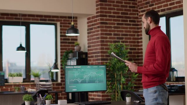 Young businessman using trade market profit data on screen to create financial investment, looking at stock charts statistics. Male broker analyzing hedge hund trend and forex exchange.