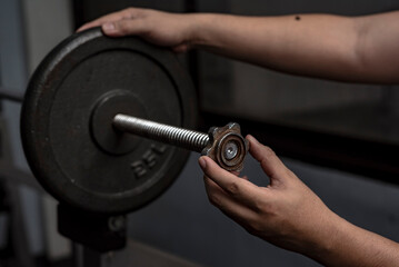 Securing a steel weight plate on a spinlock barbell bar with spinlock collars. Weightlifting and...