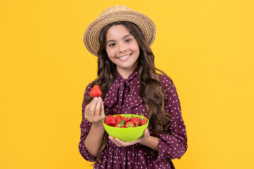 positive teen kid hold strawberry bowl on yellow background