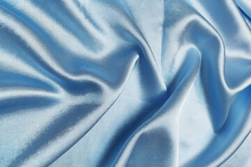 Blue crepe satin crumpled or wavy fabric texture background. Abstract linen cloth soft waves. Silk fabric. Smooth elegant luxury cloth texture. Concept for banner or advertisement.