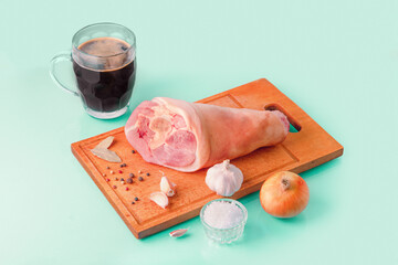 Raw Pork knuckle, dark beer and other ingredients for cooking baked pork knuckle in beer