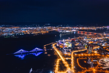 Aerial top view city Krasnoyarsk bridge through Yenisei river evening with neon light
