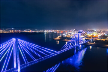 Obraz premium Aerial top view city Krasnoyarsk bridge through Yenisei river evening with neon light