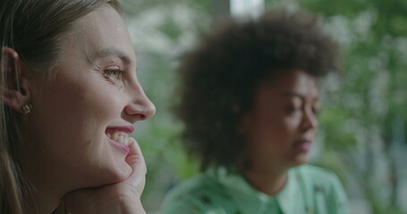 Fototapeta premium Female diverse friends hanging out together. Closeup of young women faces speaking in conversation. People at coffee shop communicating and chatting
