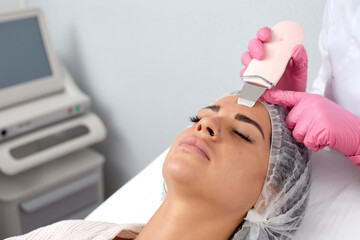 Naklejka premium Beautiful woman receiving ultrasound cavitation facial peeling. Cosmetology and facial skin care