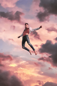 Active man flying trick against sunset cloudy sky
