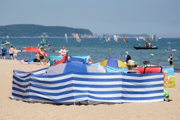 Big screen on the beach by the sea. The woman with the hat is sitting behind the screen. Baltic Sea, Sopot, Poland