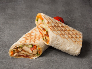shawarma with chicken and vegetables grilled on a gray background