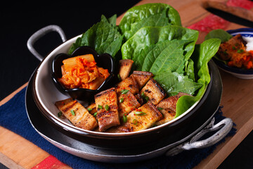 Asian food concept homemade Korean Grilled pork belly BBQ Samgyeopsal-gui with kimchi and shiso and salad on black background with copy space