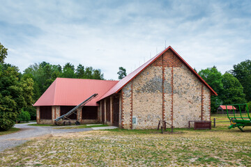 A beautiful large barn at the horse farm in Florianka. Red corrugated metal sheet on the roof of...
