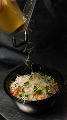 caesar salad in a plastic container is sprinkled with parmesan. concept: food delivery, food preparation