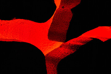 Volcano red glowing through textured rocks in display - Powered by Adobe