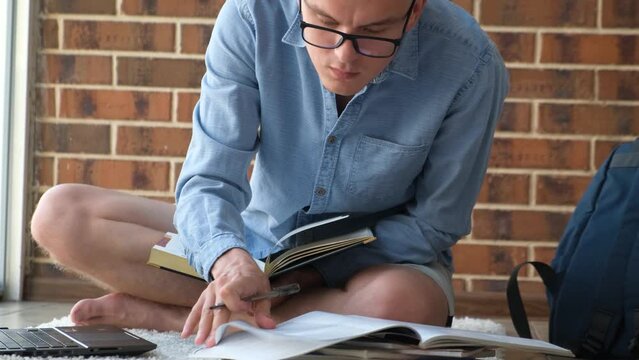 A student is fussily preparing for a session at the university sitting on the floor, closeup