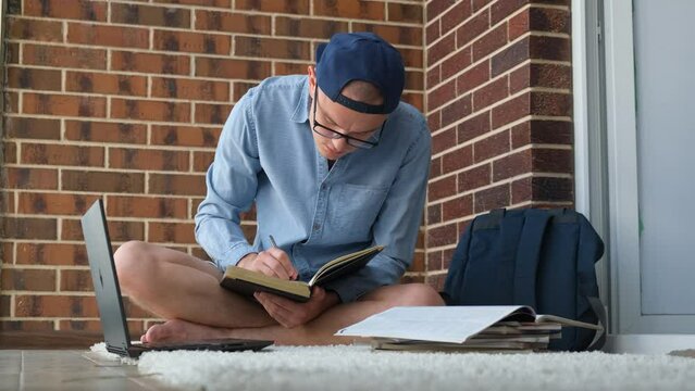 A student is fussily preparing for a session at the university sitting on the floor, closeup