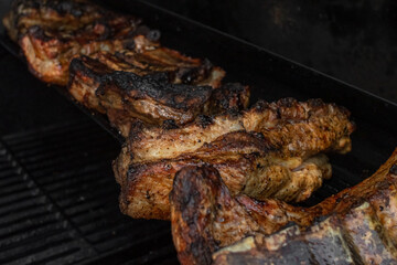 Roasted ribs. Grilled meat. Cook on fire. A ruddy crust. Fatty foods. Grilled pork. Appetizing pieces of fried meat on the grill.