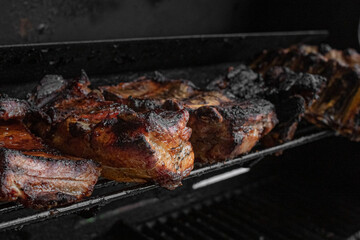 Roasted ribs. Grilled meat. Cook on fire. A ruddy crust. Fatty foods. Grilled pork. Appetizing pieces of fried meat on the grill.