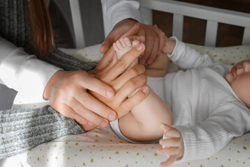 Fathers and mothers hands holding babys feet. Closeup of Hands Holding Babys Feet.