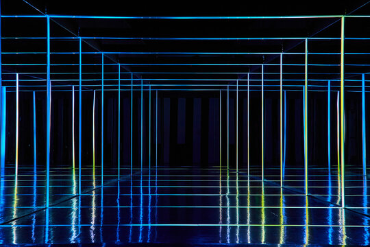 Colorful neon lights lining mirror hallway of infinity