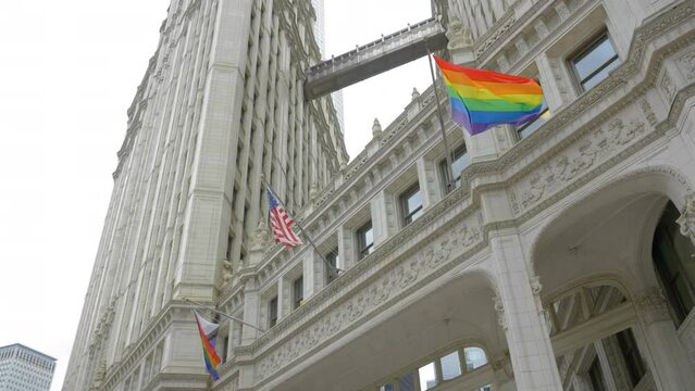 LGBTQ Rainbow and American National Flag Waving in Downtown Chicago USA, Low Angle