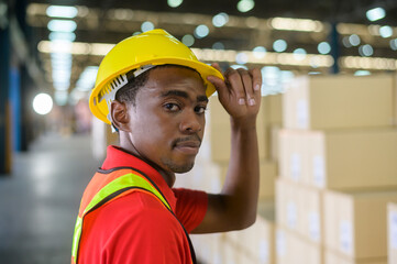 Portrait of young mixed race male worker wearing helmet in modern warehouse storage of retail shop
