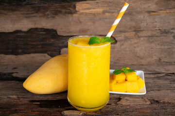 Mango juice fruit smoothies yogurt drink yellow healthy delicious taste in a glass slush for weight loss on wooden background.