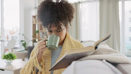 Curious woman reading story book, drinking coffee and enjoying relaxing day off in home living room. Young student studying or author interested in fairytale, fiction novel and sipping on mug of tea