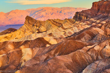 Fototapeta na wymiar Zabriskie Point colorful sediment waves of mountains in desert at sunrise