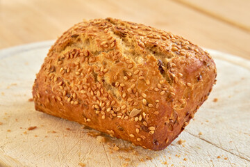 Fresh baked bread on a table at a bakery or kitchen. Homemade seeded wheat bun freshly prepared by a nutritionist baking organic, gluten free loaves, ready to be sliced and served as a meal