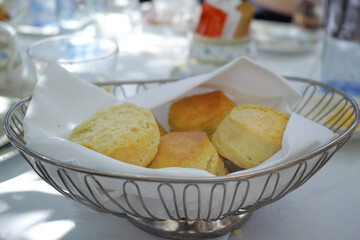 Fresh baked scones on a kitchen table at a party or event. A serving of a fresh homemade sweet snacks ready to be eaten at a family lunch. Prepared cakes for guests at a lunch date or function