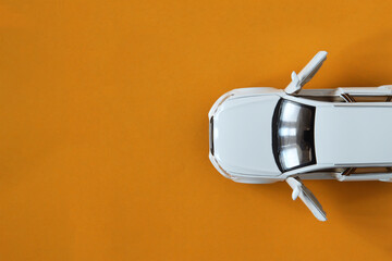White car model top view. Place for text. Road transport, auto, orange background, brown background.