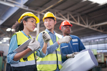 Three Heavy Industry Engineers Stand in Pipe Manufacturing Factory, Use Digital Tablet Computer, Have Discussion. Design and Construction